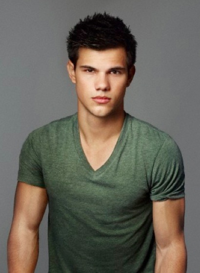 A photograph of actor Taylor Lautner with his trademarked spiky hairstyle as he poses in front of the camera with a green t-shirt